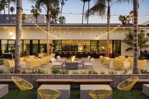 A tan building with seating and lights that are all sort of monochrome. 