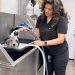 angie de santiago the salon owner of herself washing a pooch.